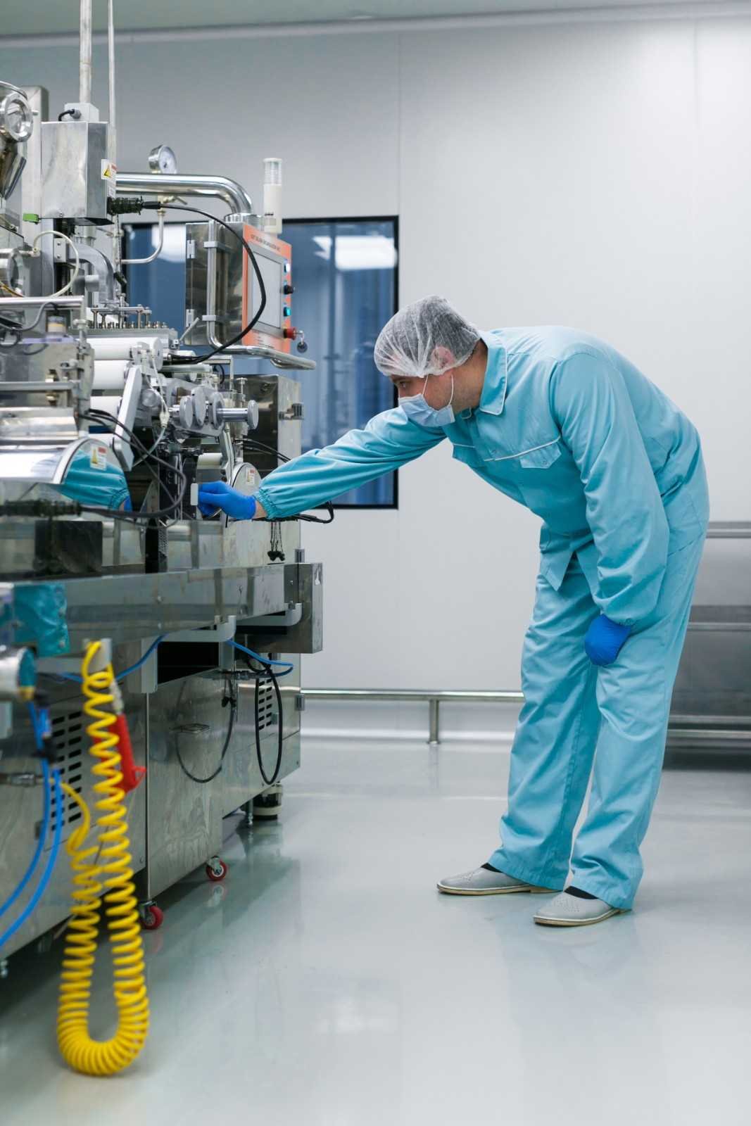 vertical-picture-bended-caucasian-scientist-blue-lab-suit-trying-fix-manufacture-machine-with-shafts-clean-factory (1)